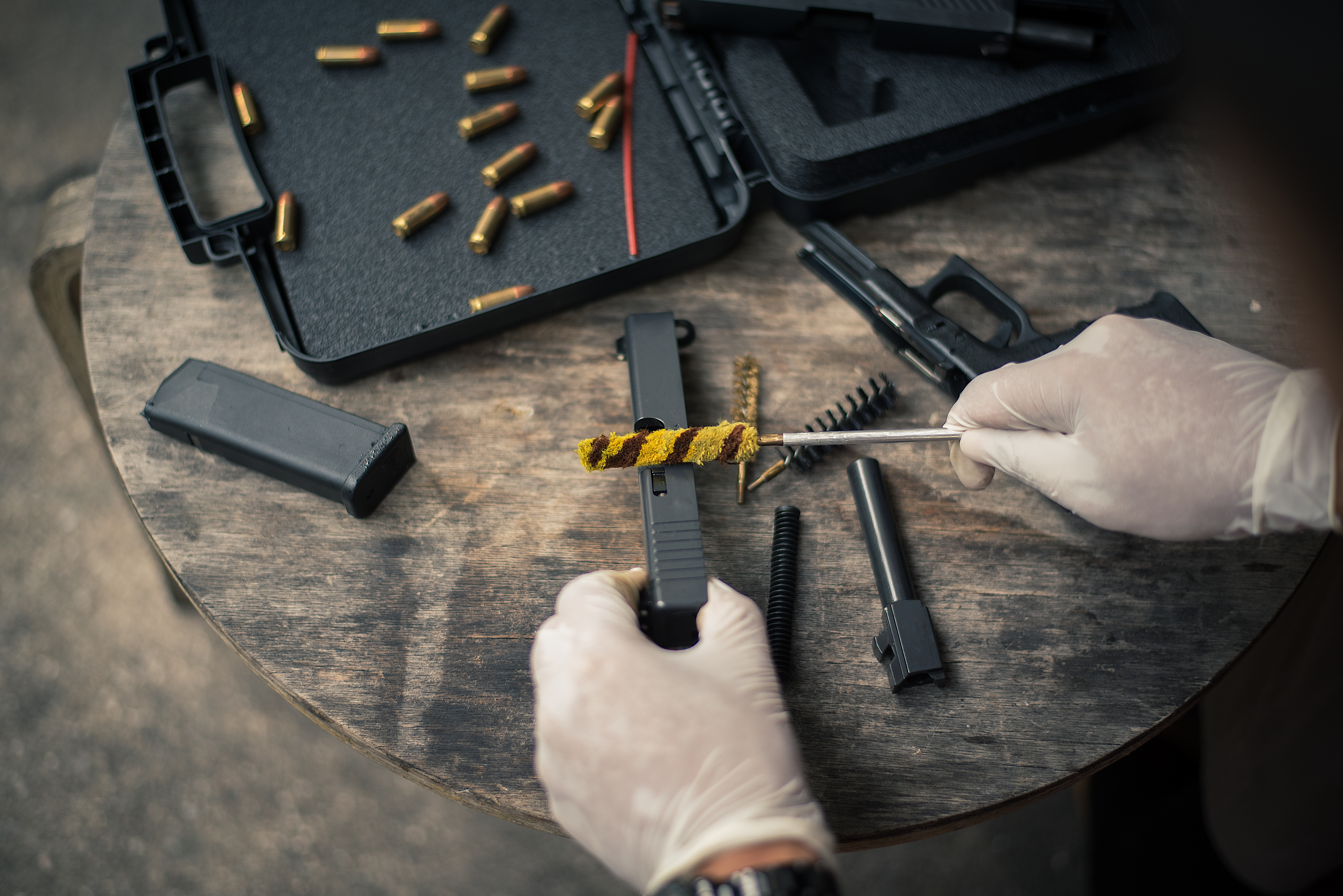 gunsmith-is-sitting-around-cleaning-gun-disassembling-maintaining-pistol (2)